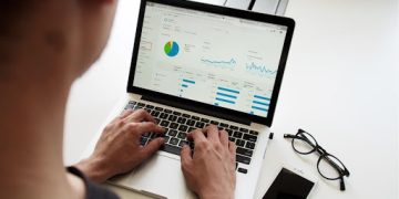 A man analyzing a pie chart on his computer